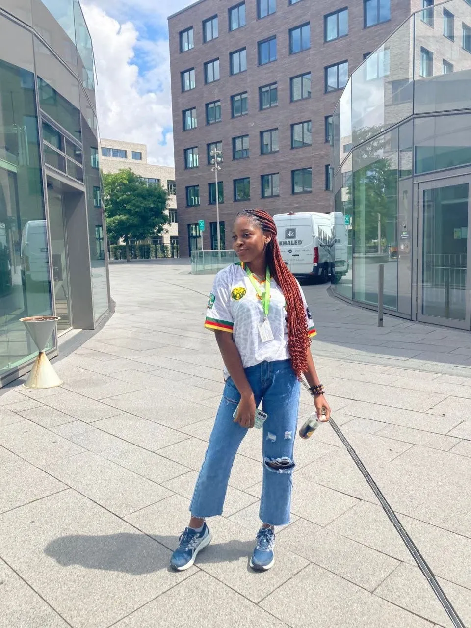 Dunou Sarah, en maillot du Cameroun, devant des bâtiments modernes en Allemagne