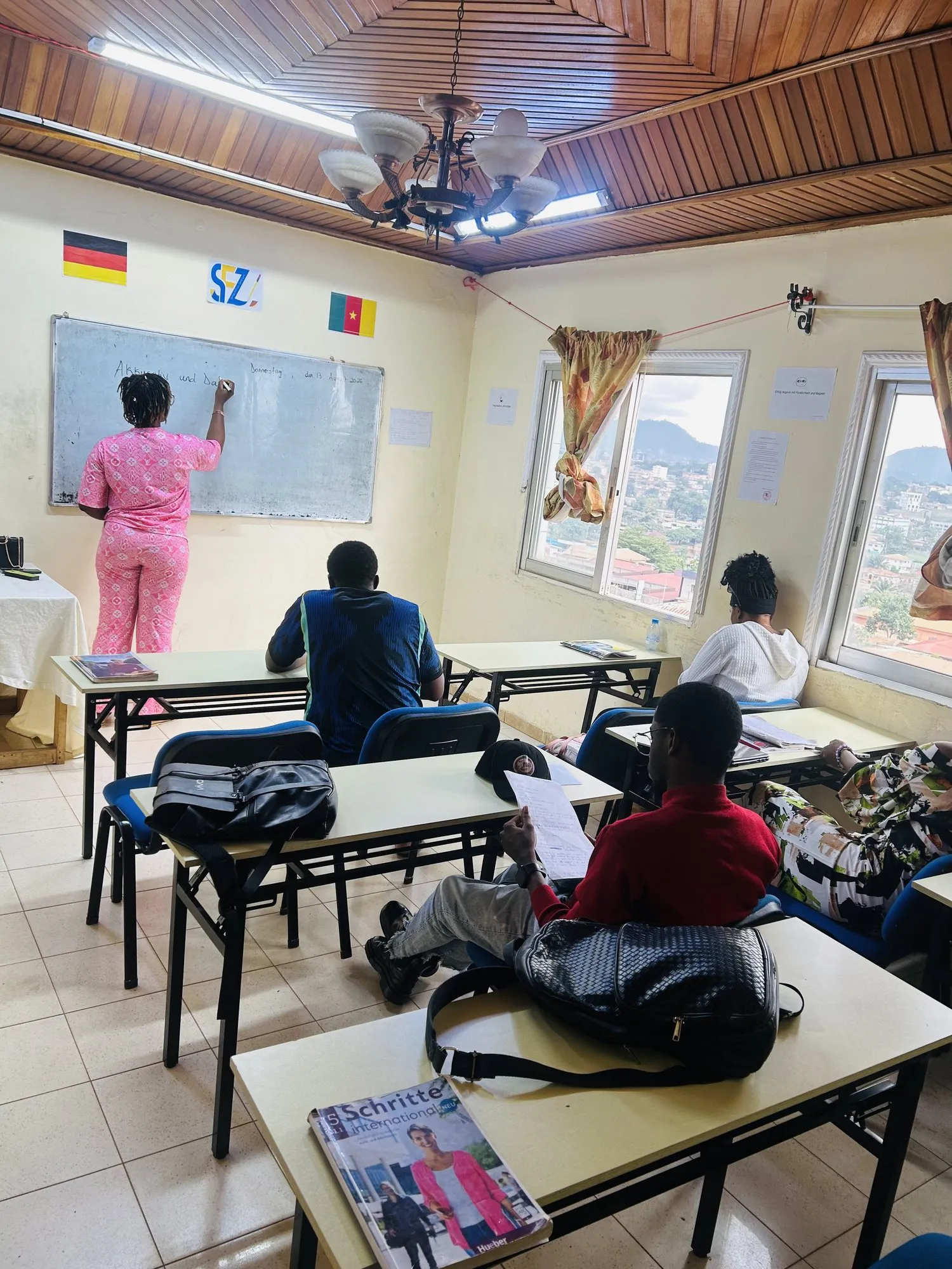 Une formatrice écrit au tableau devant un groupe d’apprenants