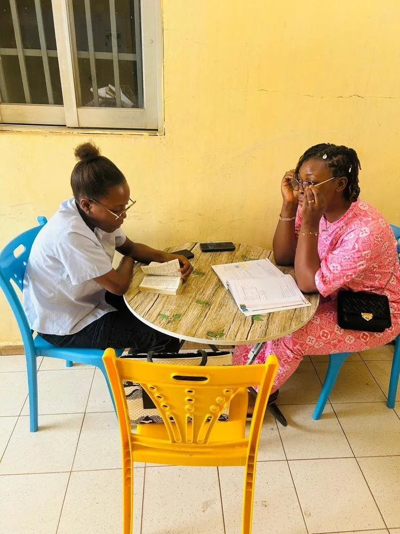 Une formatrice écrit au tableau devant un groupe d’apprenants