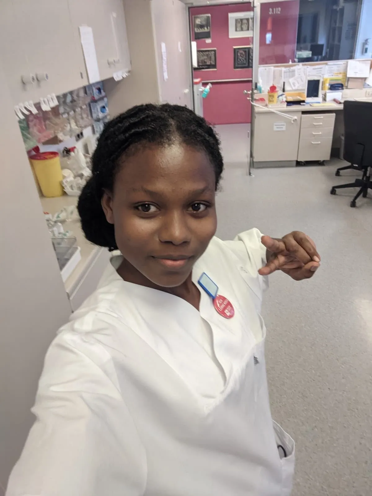 Une apprenante en tenue de soins prend un selfie dans un service hospitalier